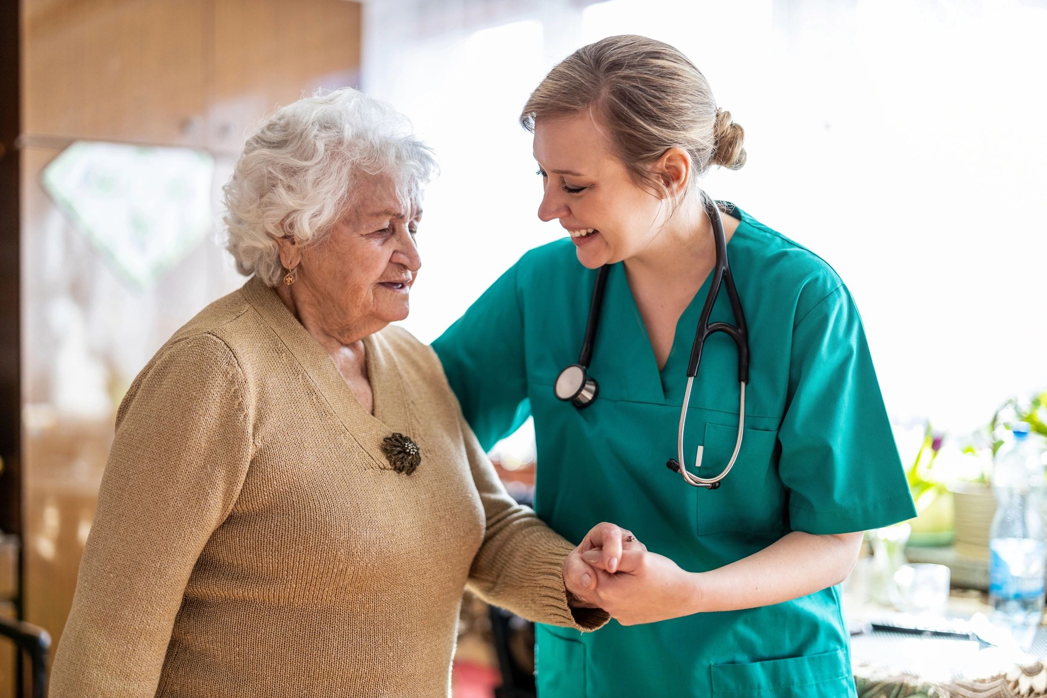 Nurse supporting an older adult while walking