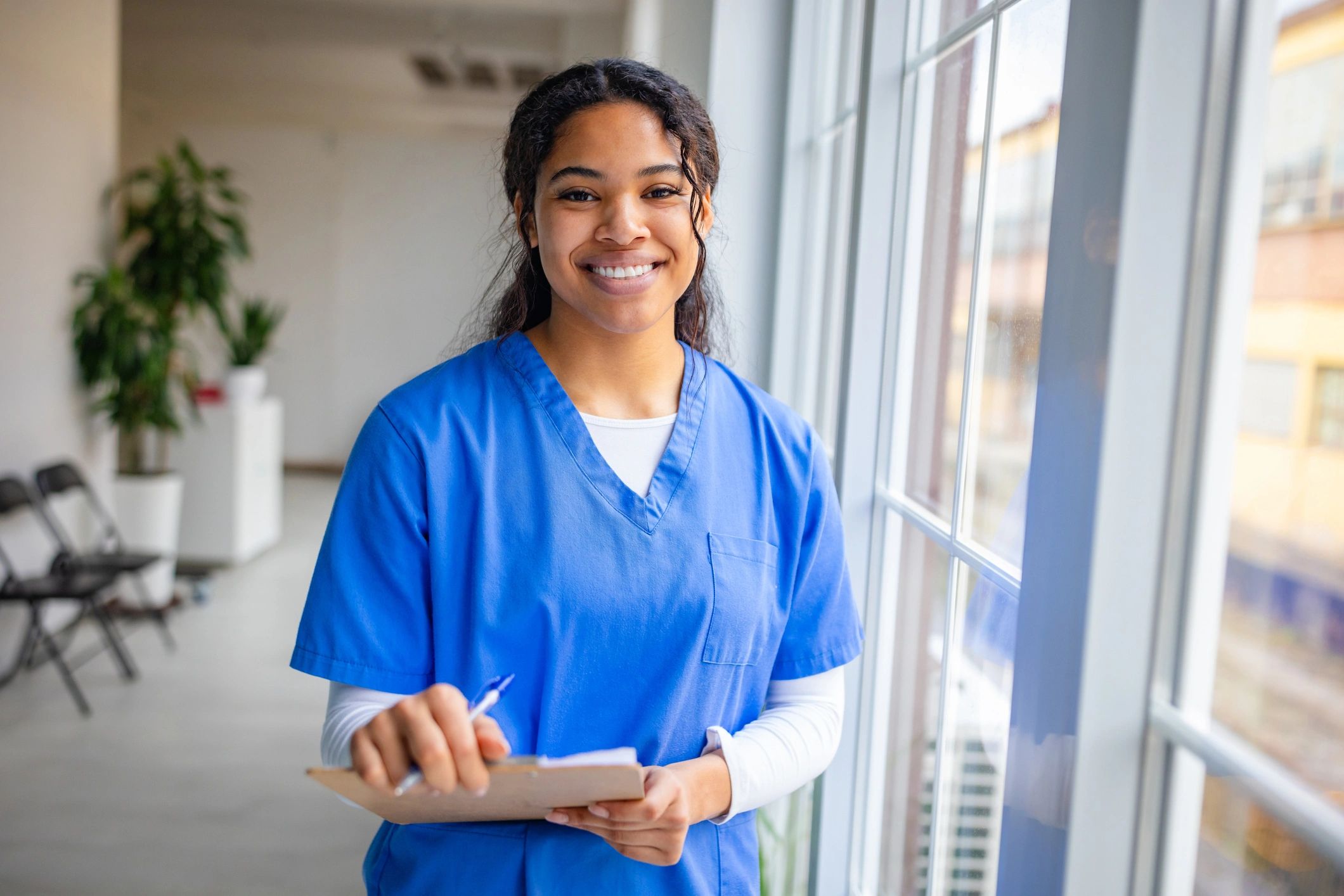 Nurse taking notes on a clipboard in a care setting