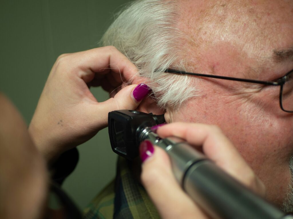 Hearing aid being fitted on a senior resident during an on-site audiology visit