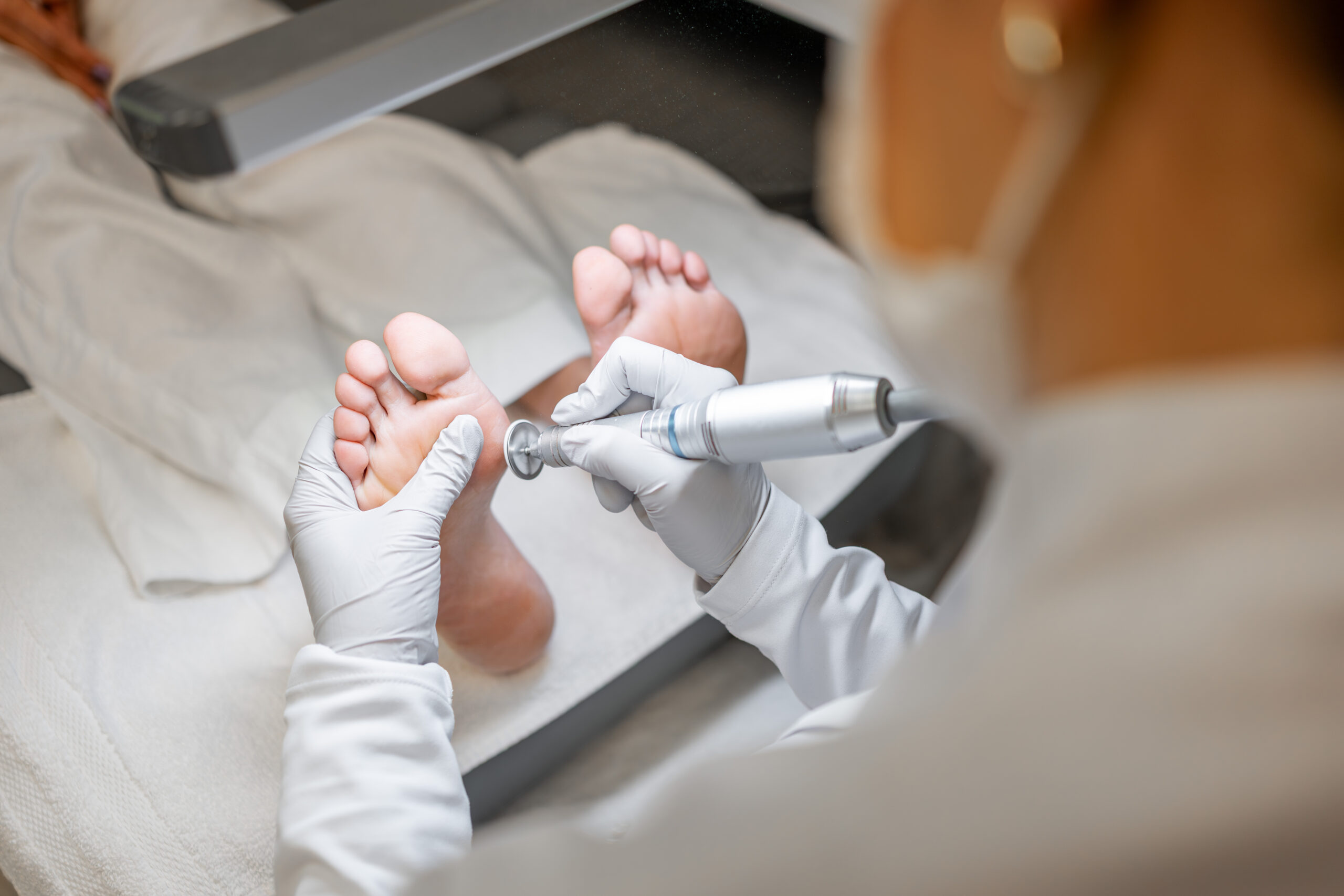 Podiatrist performing a foot care treatment on a patient during an on-site clinical visit