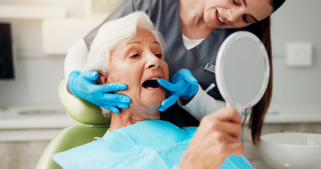 Dentist examining a senior resident's teeth during an on-site dental visit in a long-term care community