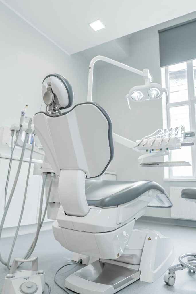 Modern dental chair and equipment in a clean, well-lit dental treatment room
